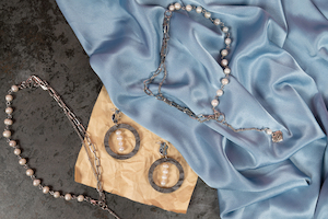 Silverhalsband med pärlor och silkesplagg